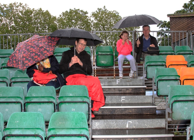 13.45, 24 June 2012: committed spectators shelter under umbrellas in the stand at Herne Hill Velodrome waiting to hear if the meeting is going ahead